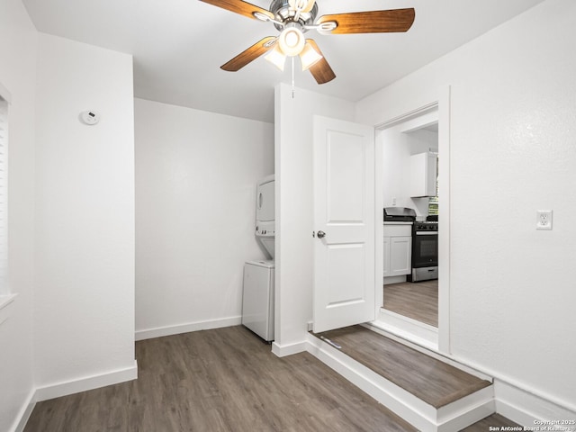 interior space with ceiling fan, stacked washer and clothes dryer, and light hardwood / wood-style floors