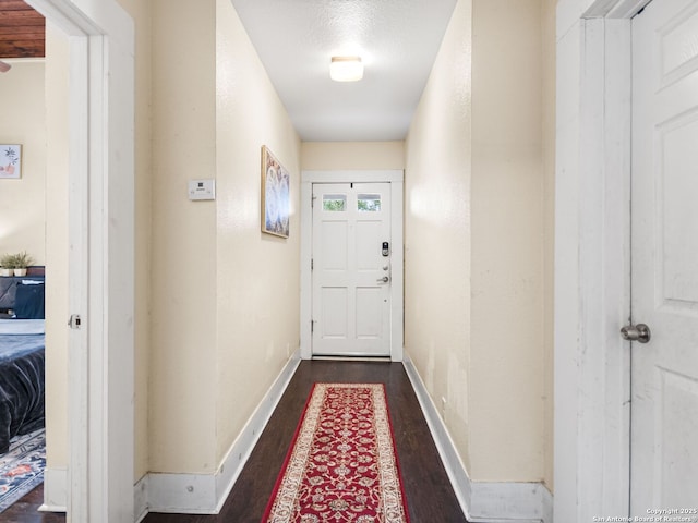 doorway to outside featuring a textured ceiling and dark hardwood / wood-style flooring