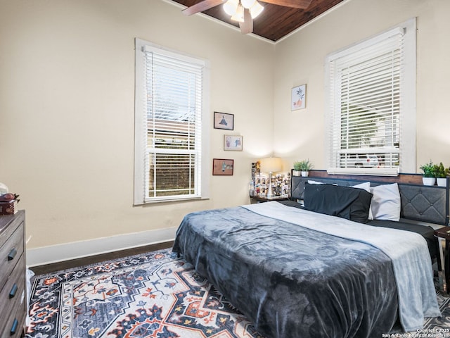 bedroom with beam ceiling, wood-type flooring, ornamental molding, and ceiling fan