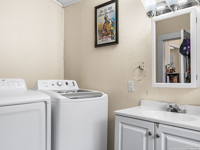 laundry area featuring cabinets, separate washer and dryer, and sink