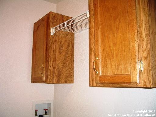 washroom featuring hookup for a washing machine and cabinets