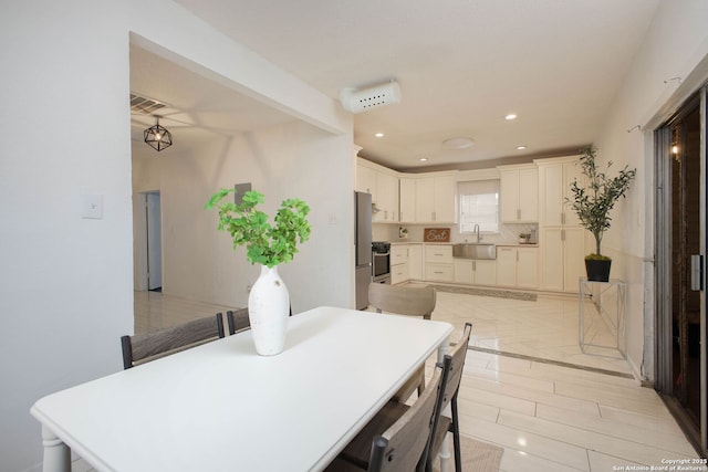 dining room featuring sink and light tile patterned floors