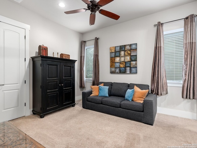 living room featuring light colored carpet and ceiling fan