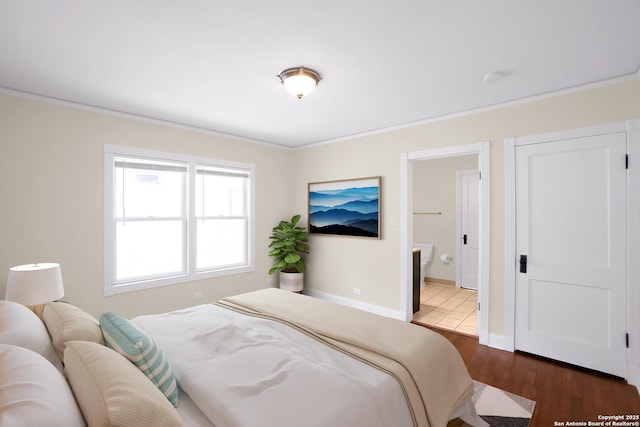 bedroom with ensuite bath, ornamental molding, and dark hardwood / wood-style floors