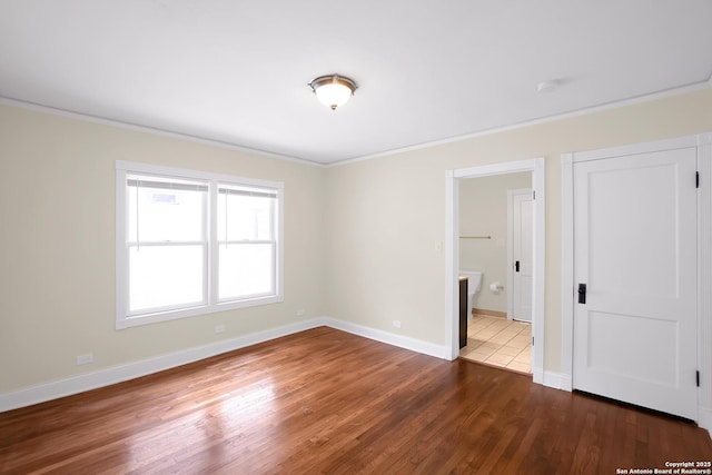 spare room with dark hardwood / wood-style flooring and crown molding