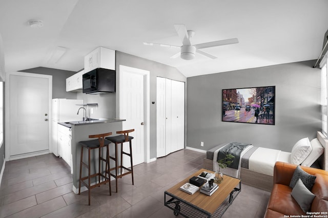 tiled living room featuring ceiling fan and lofted ceiling