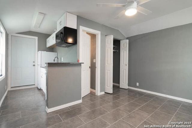 kitchen featuring white cabinetry, lofted ceiling, sink, and ceiling fan