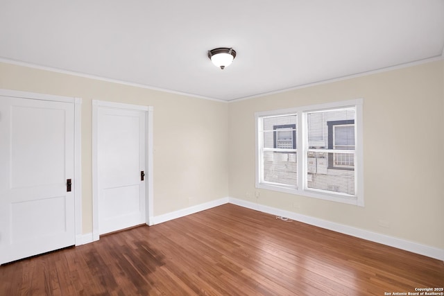 unfurnished bedroom featuring crown molding and dark hardwood / wood-style flooring