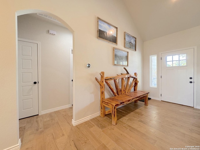 entryway with vaulted ceiling and light hardwood / wood-style flooring