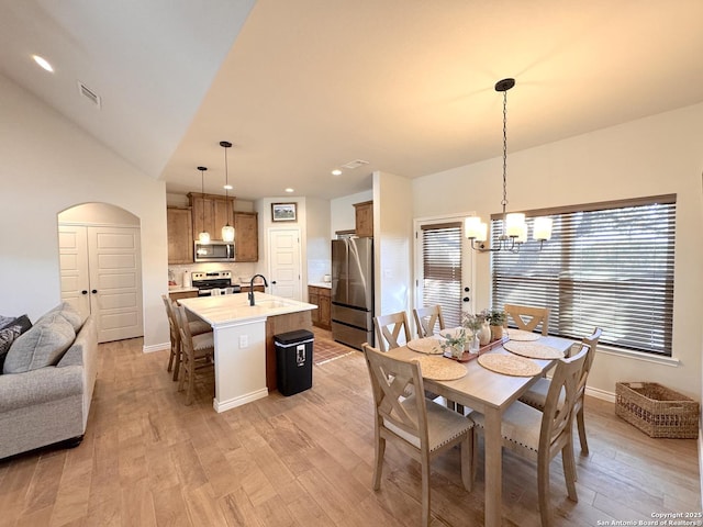 dining area featuring plenty of natural light, an inviting chandelier, and light hardwood / wood-style floors