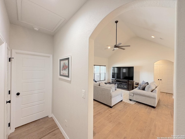 corridor featuring high vaulted ceiling and light wood-type flooring