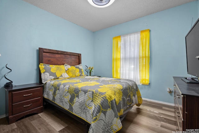 bedroom featuring hardwood / wood-style flooring and a textured ceiling