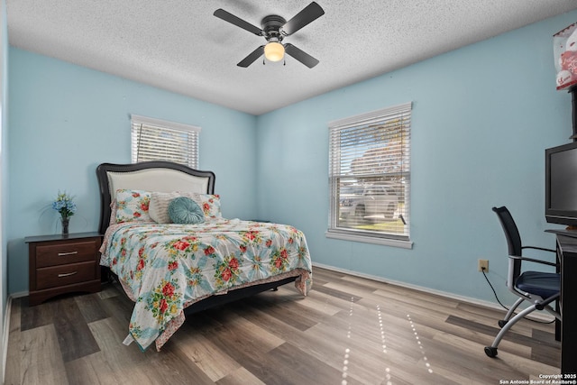 bedroom with ceiling fan, multiple windows, and a textured ceiling