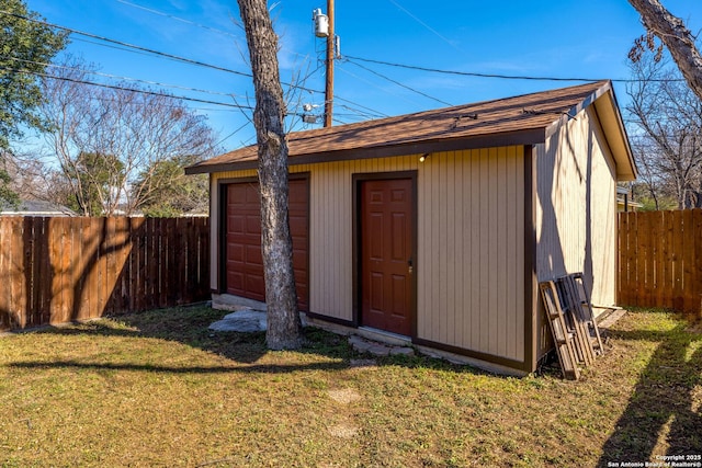 view of outbuilding with a garage and a lawn