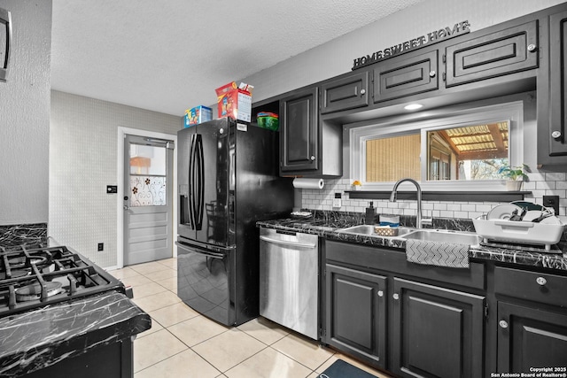 kitchen featuring dishwasher, sink, light tile patterned floors, black fridge with ice dispenser, and a textured ceiling