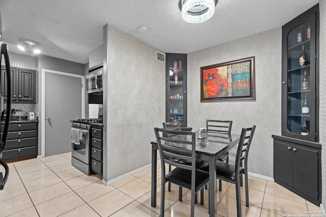 dining area featuring light tile patterned flooring and a textured ceiling