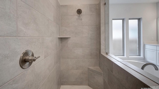 full bathroom with tiled shower and vanity