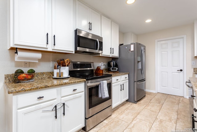 kitchen featuring light tile patterned flooring, appliances with stainless steel finishes, white cabinets, and light stone counters