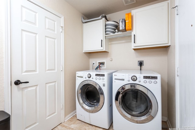 laundry area with cabinets, washer and dryer, and light tile patterned floors