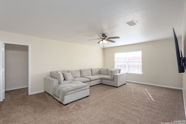 carpeted living room featuring a textured ceiling and ceiling fan