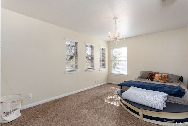 carpeted bedroom featuring a notable chandelier