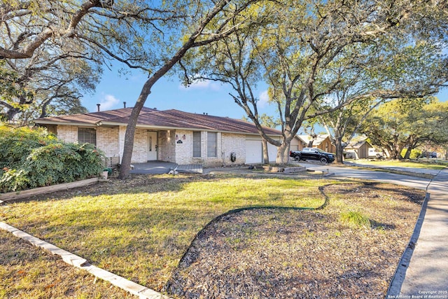 ranch-style house featuring a garage and a front lawn