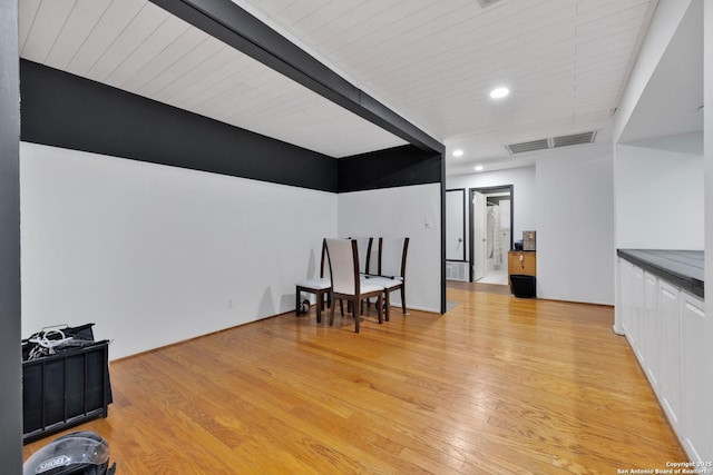 living area featuring beam ceiling, light hardwood / wood-style flooring, and wooden ceiling