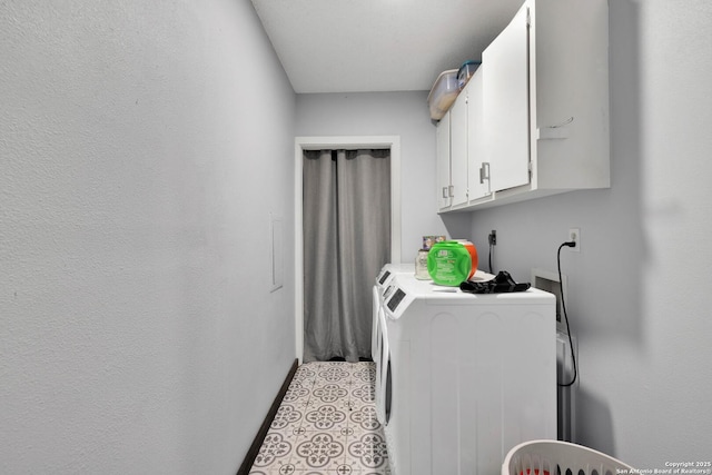 washroom featuring cabinets, light tile patterned floors, and washer and clothes dryer