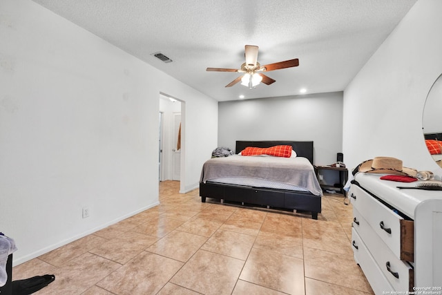 tiled bedroom with a textured ceiling and ceiling fan