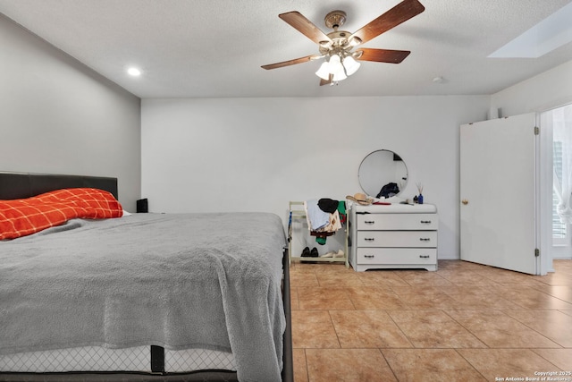 bedroom with light tile patterned floors, a textured ceiling, and ceiling fan