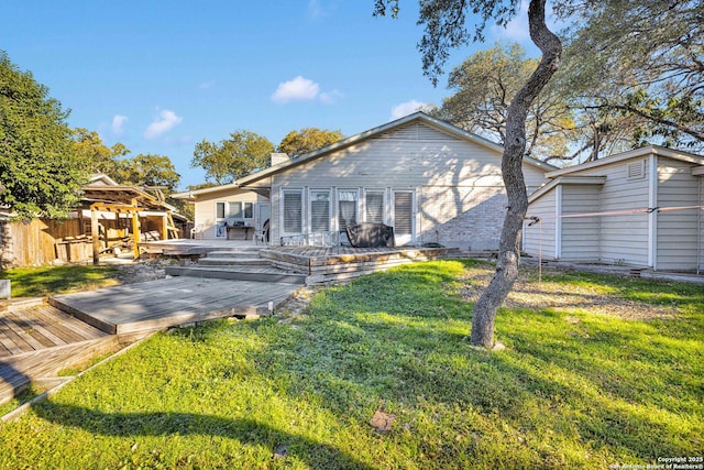 back of property with a yard and a deck