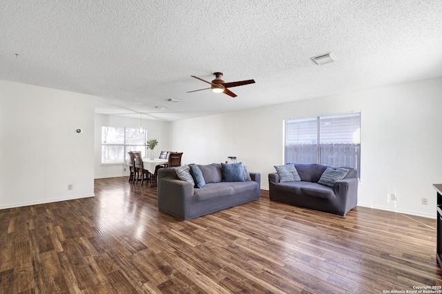 living room with ceiling fan, dark hardwood / wood-style floors, and a textured ceiling