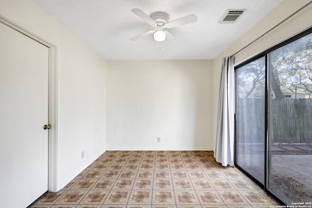 empty room with ceiling fan and a textured ceiling