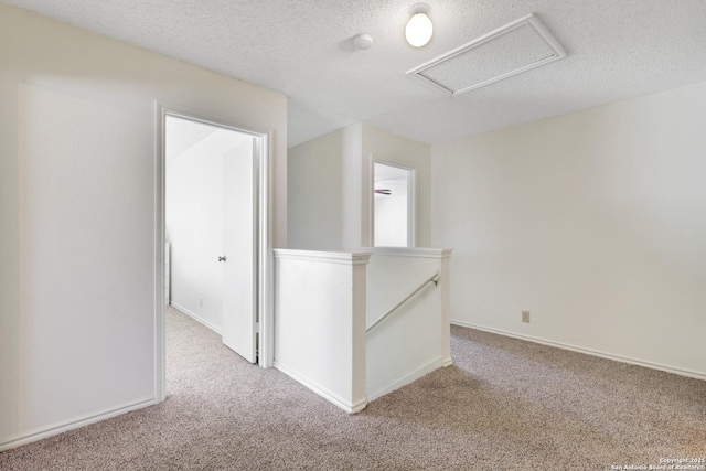 carpeted empty room with a textured ceiling