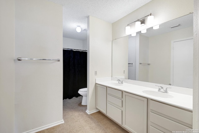 bathroom with vanity, a textured ceiling, and toilet