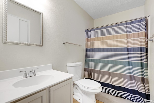 bathroom featuring vanity, a textured ceiling, and toilet