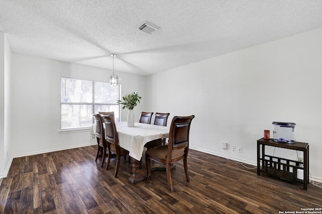 dining area with dark hardwood / wood-style flooring and a textured ceiling