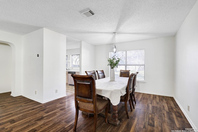 dining area with a textured ceiling and dark hardwood / wood-style flooring