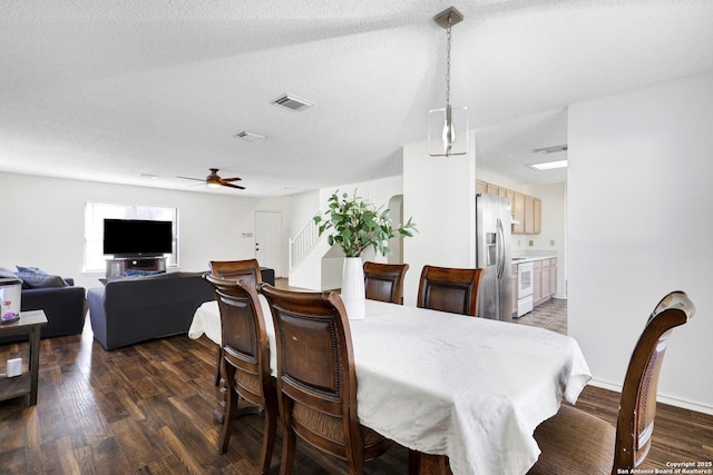 dining space featuring ceiling fan, dark wood-type flooring, and a textured ceiling