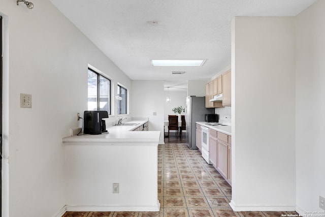 kitchen featuring electric stove, sink, light brown cabinetry, and stainless steel refrigerator