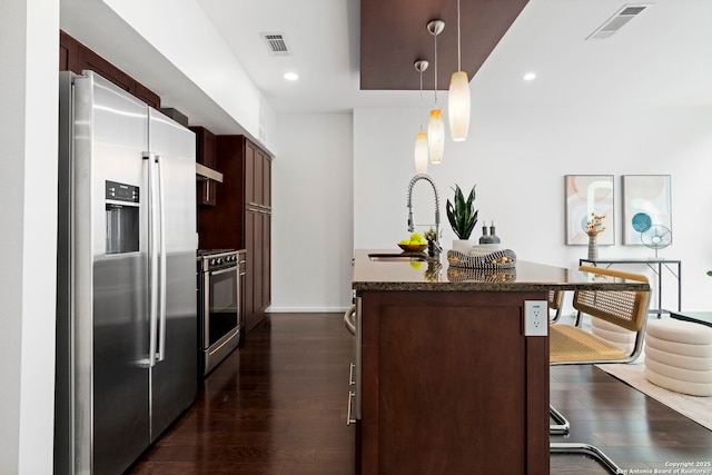 kitchen featuring pendant lighting, sink, a breakfast bar area, stove, and stainless steel refrigerator with ice dispenser