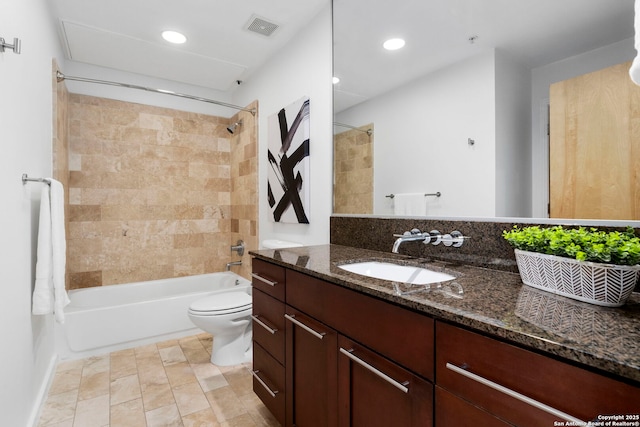 full bathroom with tiled shower / bath, vanity, and toilet