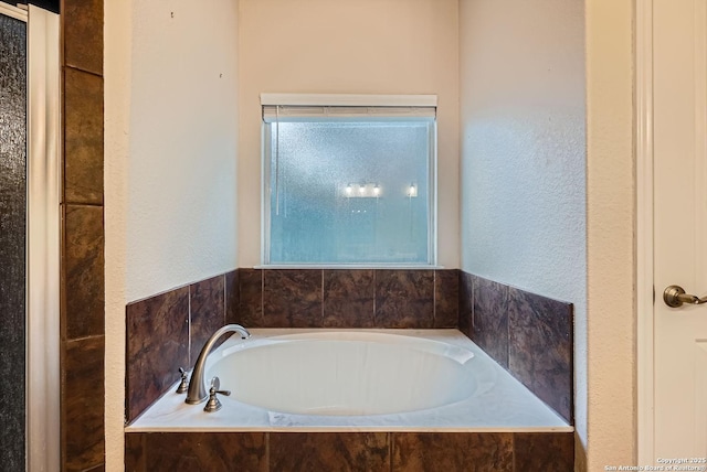 bathroom featuring tiled tub