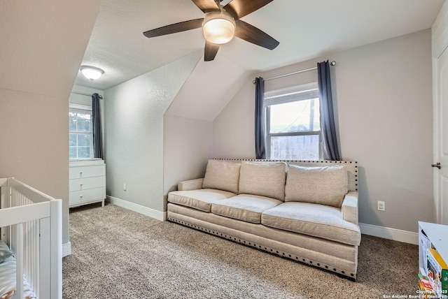 carpeted bedroom with ceiling fan, lofted ceiling, and a crib