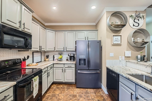 kitchen featuring sink, gray cabinetry, ornamental molding, light stone countertops, and black appliances