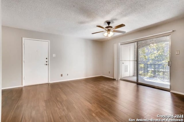 spare room featuring ceiling fan, dark hardwood / wood-style floors, and a textured ceiling