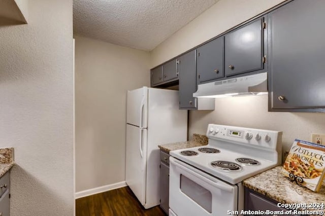 kitchen with dark hardwood / wood-style flooring, white appliances, gray cabinets, and a textured ceiling