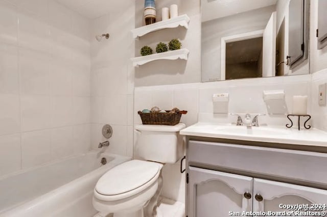 full bathroom featuring tile walls, backsplash, tiled shower / bath combo, vanity, and toilet