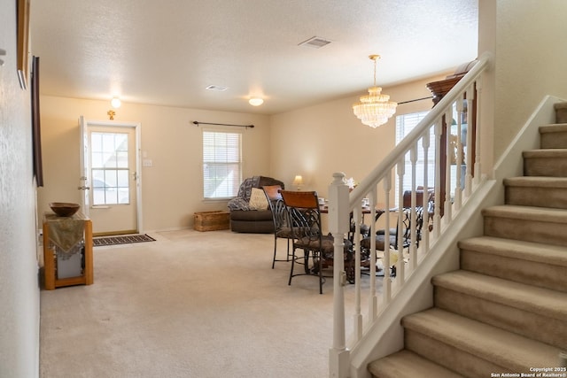 interior space featuring a textured ceiling, carpet, and a notable chandelier