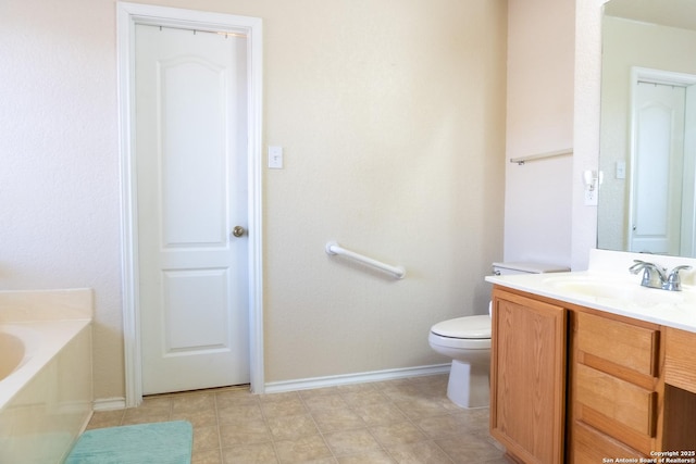 bathroom featuring vanity, toilet, and a washtub